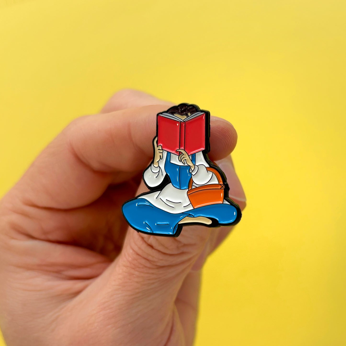 Pin metálico Bella leyendo